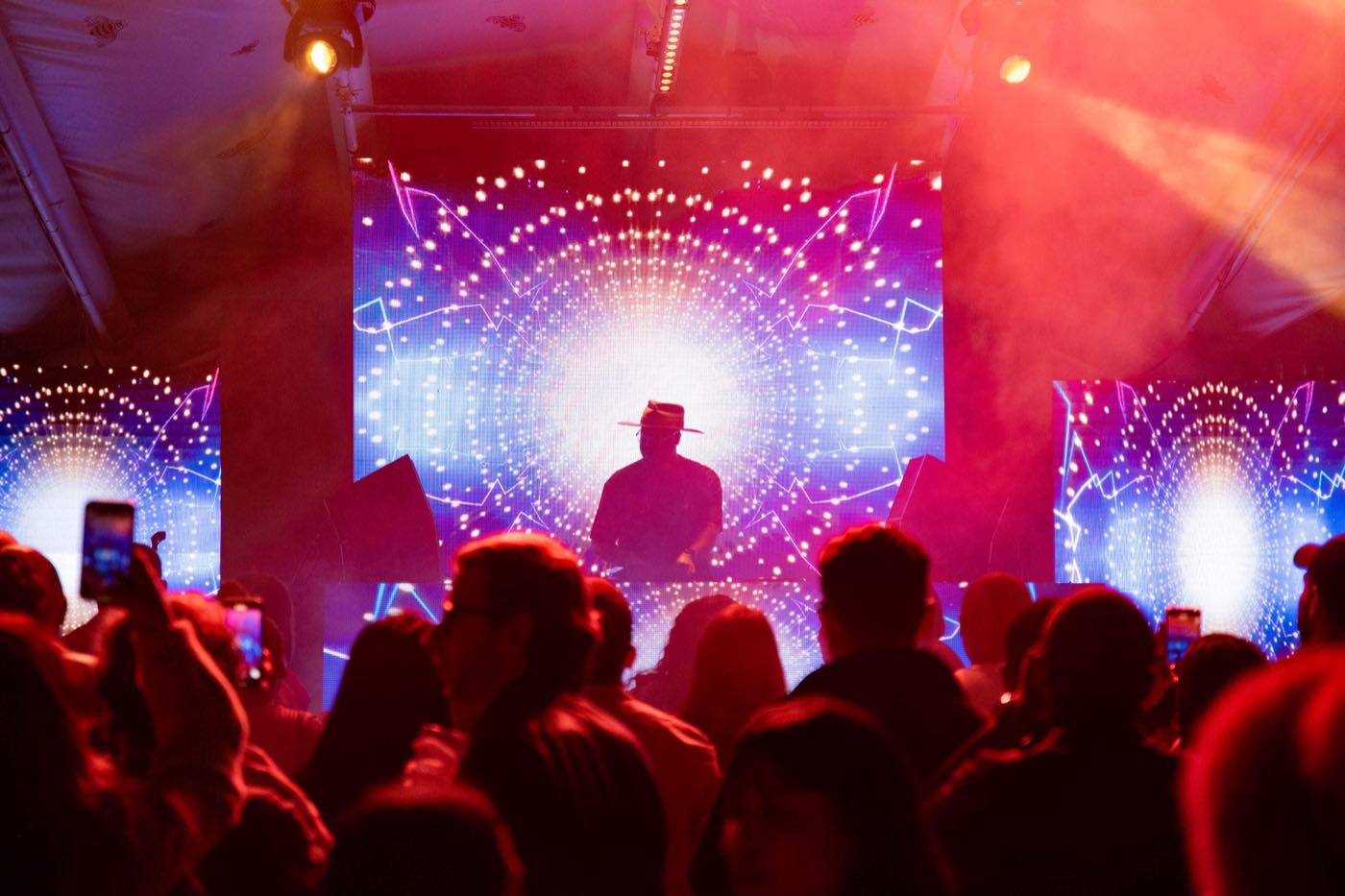 An Aṣẹ crowd in front of the stage, phones raised
